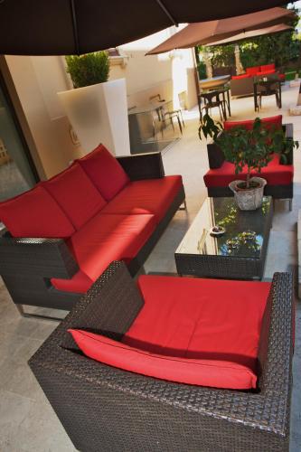 a living room with a red couch and chairs at UNAHOTELS Villa dei Platani Foligno in Foligno