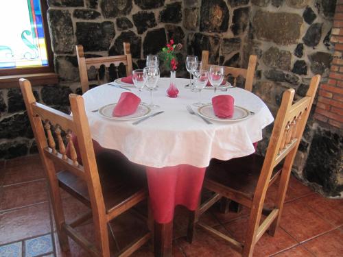 a table with a white table cloth and wine glasses at Casa Pardo in Gibaja