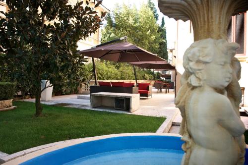 a statue of a girl standing next to a pool at UNAHOTELS Villa dei Platani Foligno in Foligno