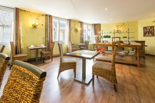a dining room with a table and chairs at Contact Hôtel Le Relais de Vellinus in Beaulieu-sur-Dordogne