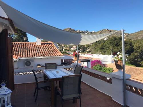 a patio with a table and chairs on a roof at Casa con encanto en El Portet de Moraira in Rada de Moraira