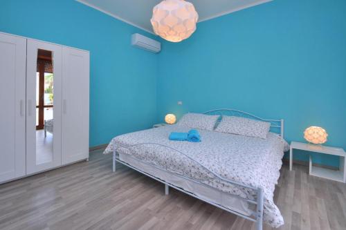 una camera blu con un letto e una parete blu di Casa Venere a Paestum