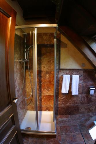 a bathroom with a shower with towels on the wall at Hotel & Spa Casa Irene in Arties