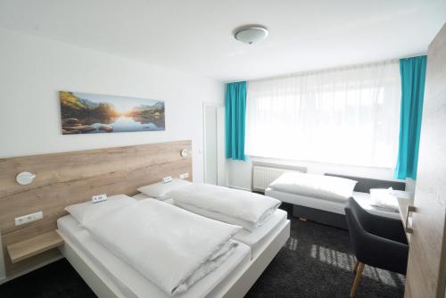 a hotel room with two beds and a desk at Hotel zur Sonne in Bodelshausen