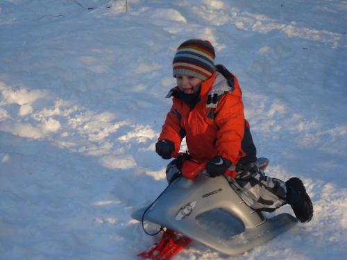 a young boy riding a snowmobile in the snow at Landhaus Ferk in Unterburg am Klopeiner See