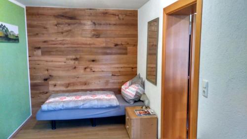 a bedroom with a wooden accent wall and a bed at Ferienwohnung Maringer in Ungenach