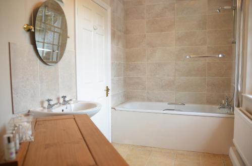 a bathroom with a tub and a sink and a bath tub at Rhydspence in Hay-on-Wye