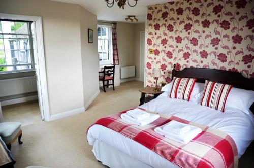 a bedroom with a bed with a red and white blanket at Rhydspence in Hay-on-Wye