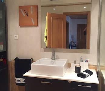 ein Badezimmer mit einem weißen Waschbecken und einem Spiegel in der Unterkunft Your place in Faro in Faro