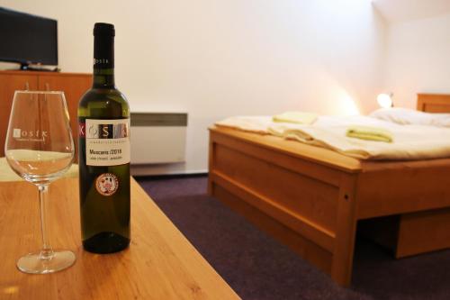 a bottle of wine sitting on a table with a glass at Penzion Kosík Tvrdonice in Tvrdonice