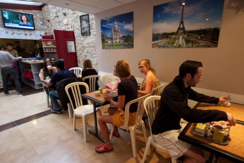 a group of people sitting at tables in a restaurant at Auberge Internationale des Jeunes in Paris