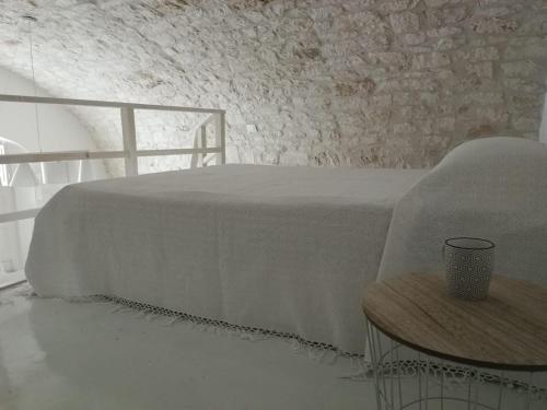 a bedroom with a white bed and a table at Solis Domus - Meridies in Ostuni
