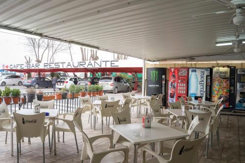 アルバセテにあるHostal Los Gabrielesのテーブルと椅子のあるレストラン、駐車場
