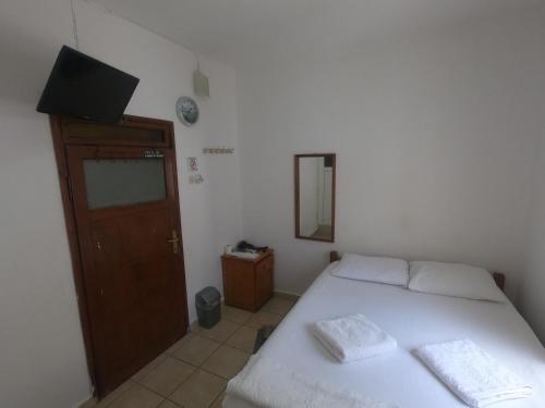 a bedroom with a bed and a mirror and a door at Merhaba Pansiyon in Bodrum City