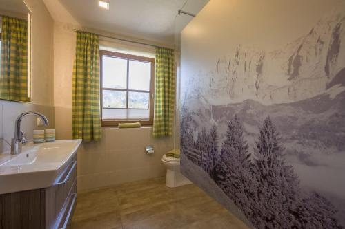 a bathroom with a mountain mural on the wall at Gästehaus Schwaiger - Wiesenweg in Kössen