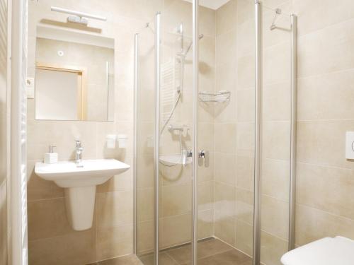 een badkamer met een glazen douche en een wastafel bij Penzion Adéla in Rožnov pod Radhoštěm