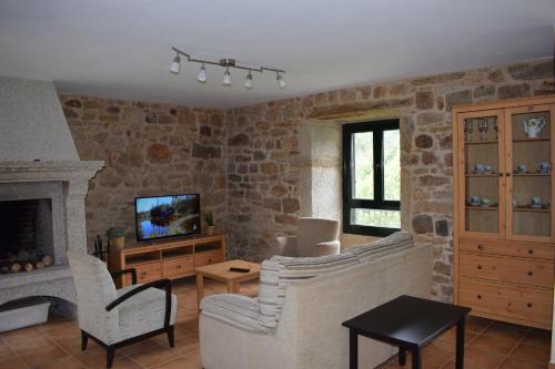 卡馬里納斯的住宿－Xaviña Camariñas，客厅配有两把椅子和壁炉
