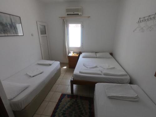a small room with two beds and a window at Merhaba Pansiyon in Bodrum City