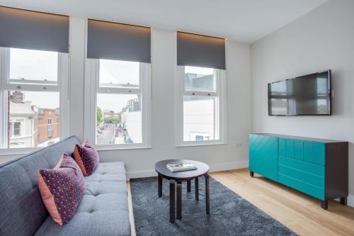 a living room with a couch and a tv at Chapel Market Serviced Apartments by Concept Apartments in London