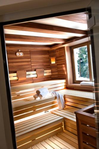 a sauna with wooden walls and a window at Hotel Chalet Tianes - Alpine Relax in Castelrotto