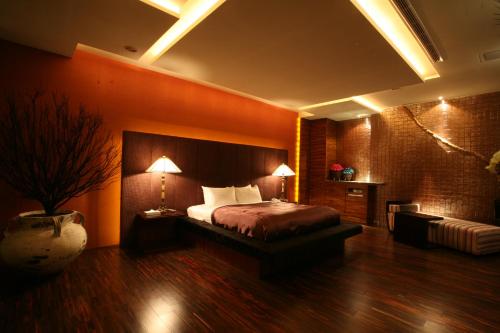 a hotel room with a bed and a couch at Chateau Boutique Motel in Taichung