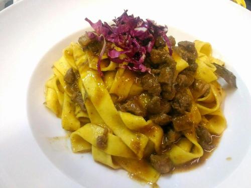 a white plate of pasta with meat and sauce at Il Castello in Petralia Sottana