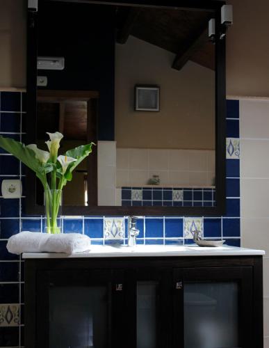 a bathroom with a sink and a vase with a plant at O Plantio in O Porto de Espasante