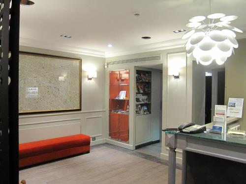 a waiting room with a red bench and a desk at Hôtel Harvey in Paris