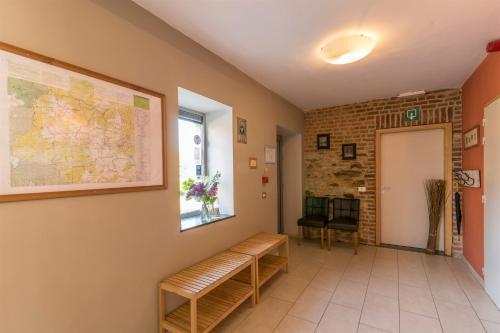 a waiting room with a bench and a map on the wall at Maison Berton in Gedinne