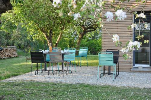 un grupo de sillas y una mesa frente a una casa en L'Atelier en Sainte-Marie-du-Lac-Nuisement 