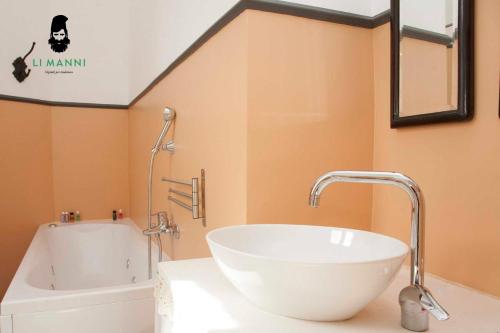 een badkamer met een witte wastafel en een bad bij Locanda Li Manni in Aggius
