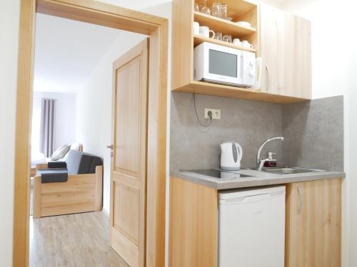 a small kitchen with a sink and a microwave at Penzion Adéla in Rožnov pod Radhoštěm