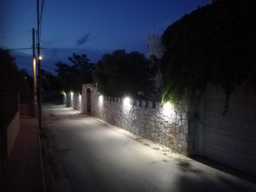 an empty street with lights on a wall at night at Castle By The Sea in Artemida