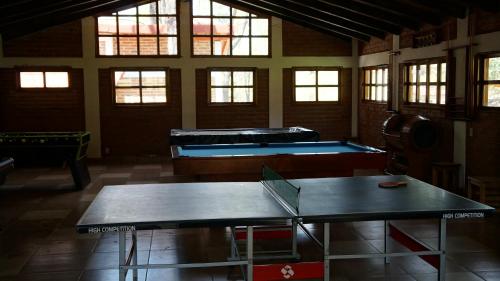 a room with two ping pong tables and windows at Rincón del Bosque in Mazamitla