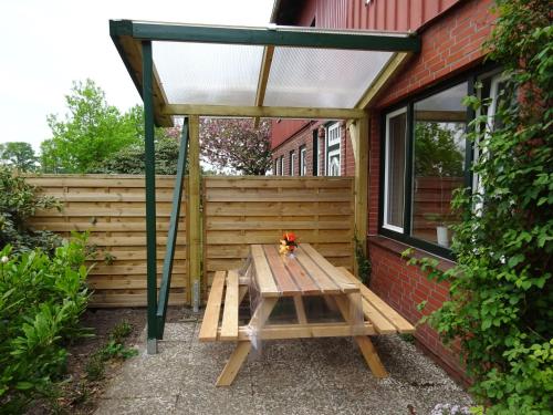 - une table de pique-nique sous un auvent sur une terrasse dans l'établissement Ferienwohnung Wisbek, à Brinjahe