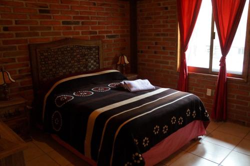 a bedroom with a bed in a brick wall at Rincón del Bosque in Mazamitla