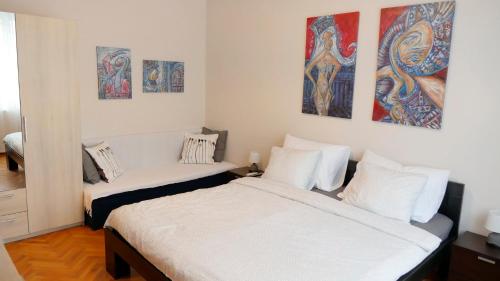 una camera da letto con due letti e quadri alle pareti di Apartman Mia a Belgrado
