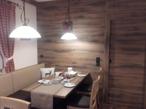 a dining room with a table and chairs and two lights at Gästehaus Alpenblick in Berwang