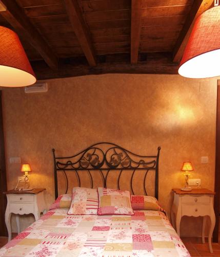 a bedroom with a bed with two nightstands and two lamps at O Plantio in O Porto de Espasante