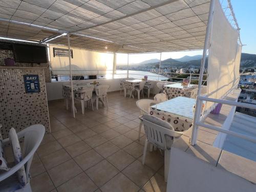 a restaurant with tables and chairs on a balcony at Merhaba Pansiyon in Bodrum City