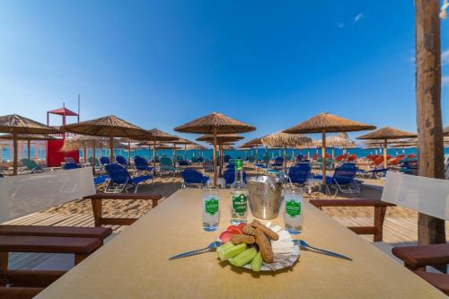 una mesa con un plato de comida en la playa en Tropical Beach A, en Amoudara Herakliou
