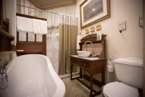 e bagno con vasca, servizi igienici e lavandino. di Schoon Huis Manor a Kempton Park