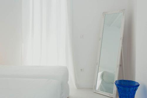 a mirror sitting next to a bed in a room at Aether Boutique Stay in Glastros
