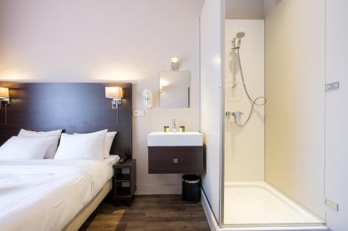 a bedroom with a bed and a shower and a sink at Best Budget Rooms in Brussels