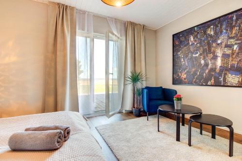 a bedroom with a bed and a table and a chair at Mereranna Puhkemajad in Orissaare