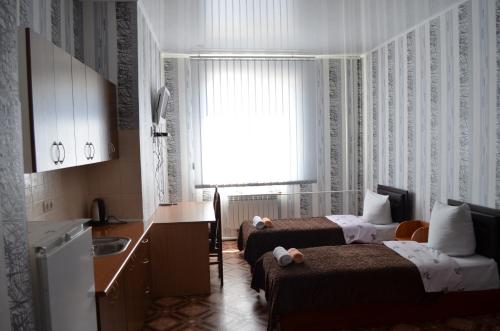 a hotel room with two beds and a kitchen at SunLake Hotel Osokorki in Kyiv