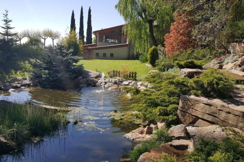 un arroyo en un jardín con una casa en el fondo en Cal Majoral, en L'Espunyola
