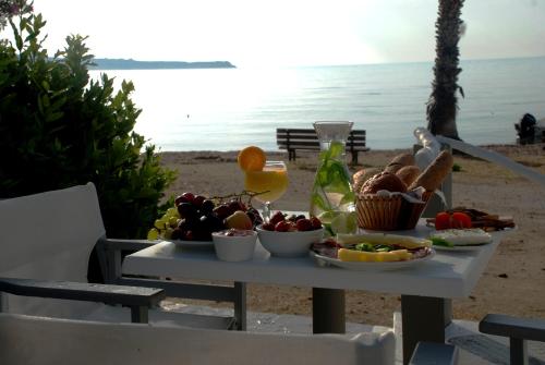 a table with food and drinks on the beach at Casa Montzo boutique hotel in Katelios