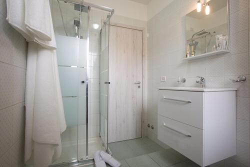 biała łazienka z prysznicem i umywalką w obiekcie Residence "Canta" w mieście Pescara