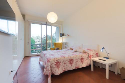 a bedroom with a bed and a table and a window at Roommo Savonarola in Florence